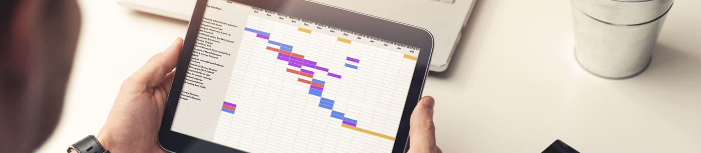 Initiation / Accompagnement de projet project-manager-looking-at-gantt-chart-on-digital-tablet-in-office